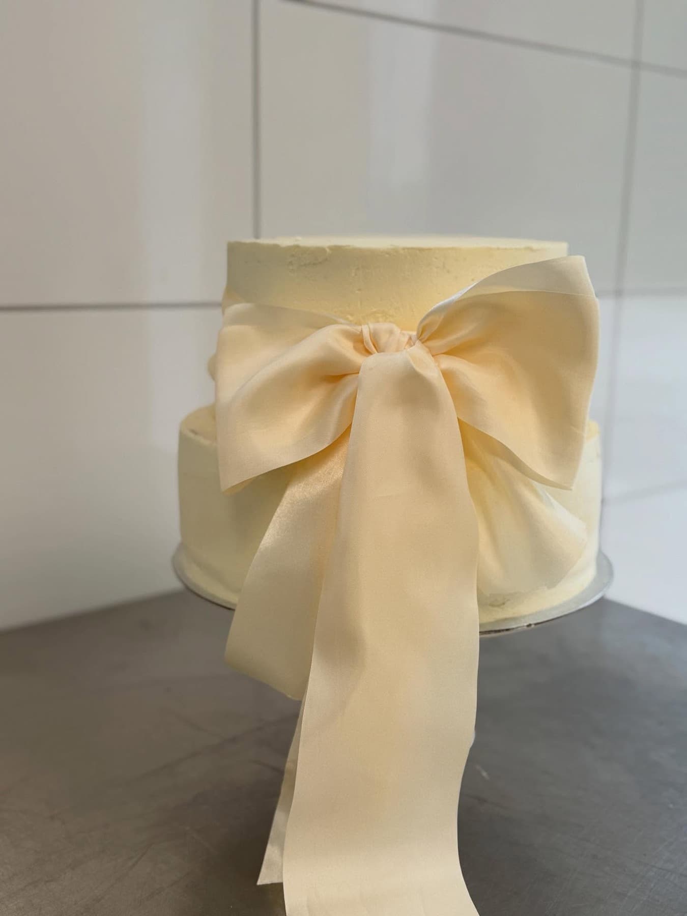 Elegante weiße Torte mit großer Schleife aus Fondant