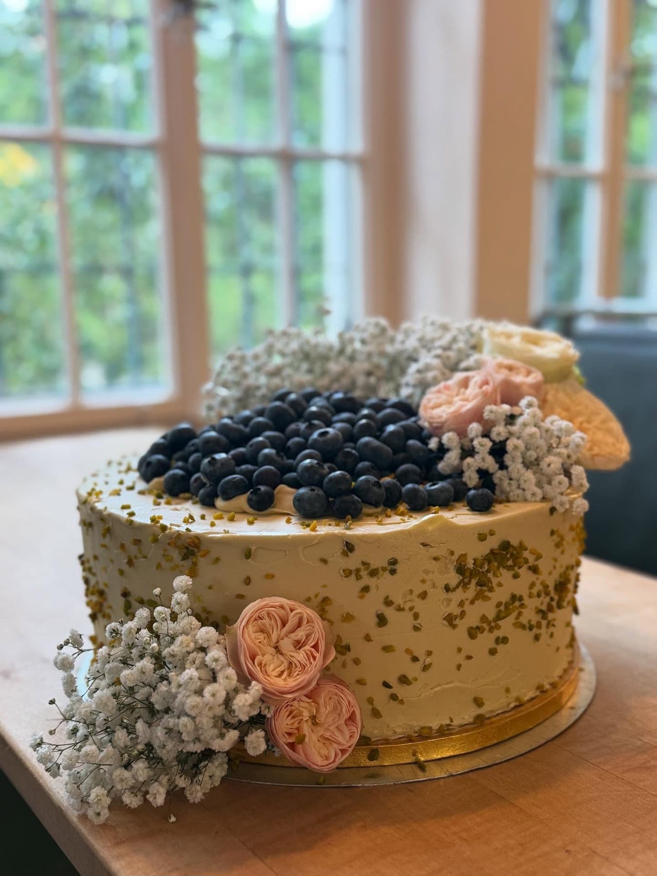 Goldene Pistazientorte mit Blaubeeren und Schleierkraut