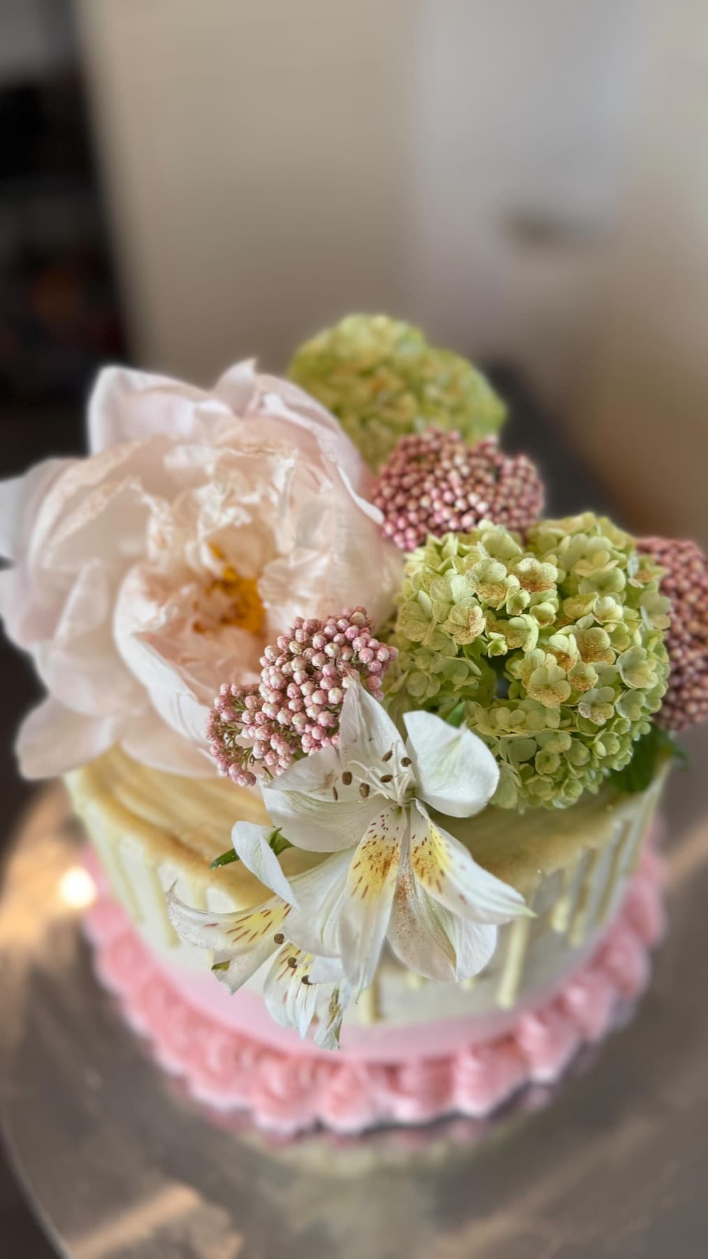 Kleine Torte mit Rüschenrand in Rosé und zarten Blüten