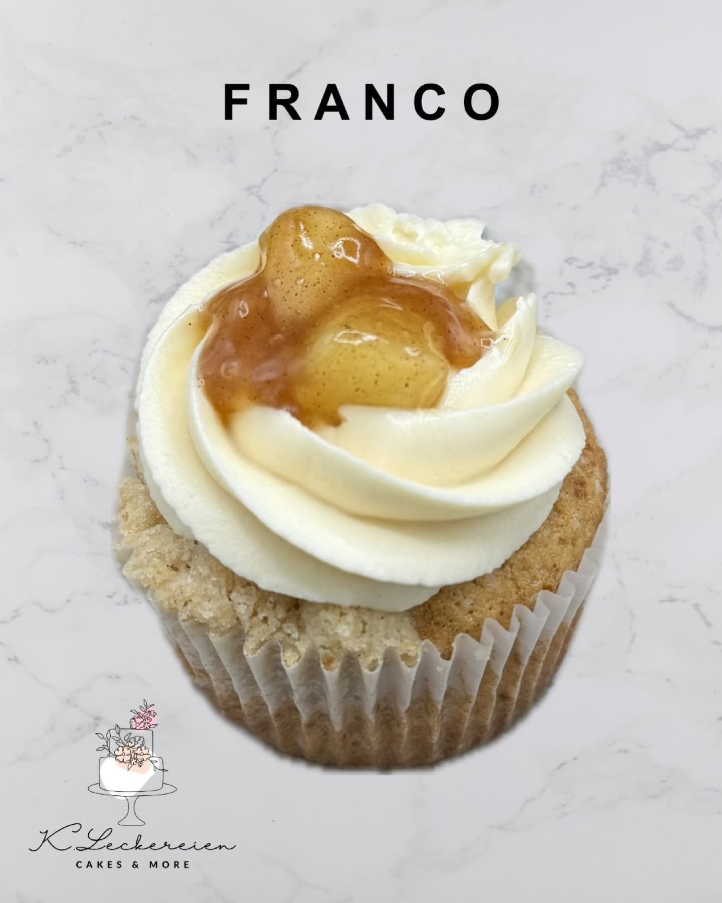 Cupcake mit Frischkäsecreme und Fruchtkern auf Marmoruntergrund
