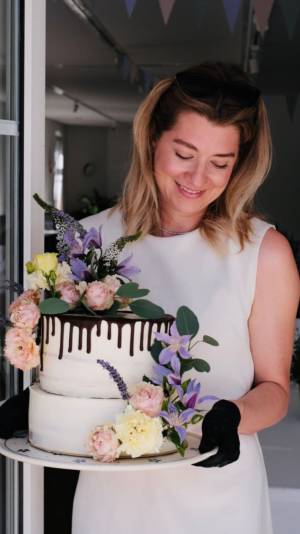 Kerstin Ederer trägt eine fertig dekorierte Hochzeitstorte