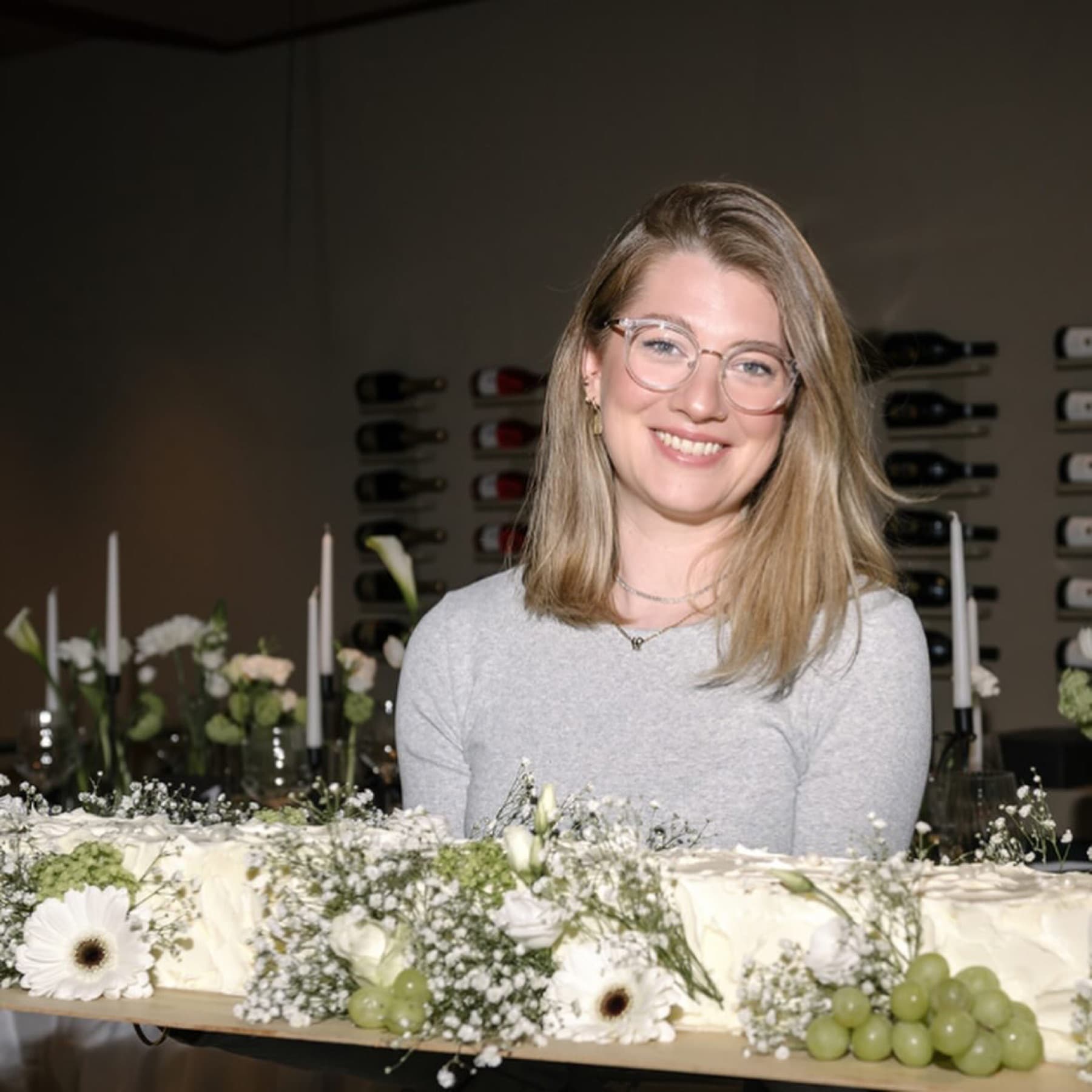 Kerstin Ederer präsentiert eine lange Sweet Table mit Blüten und Trauben