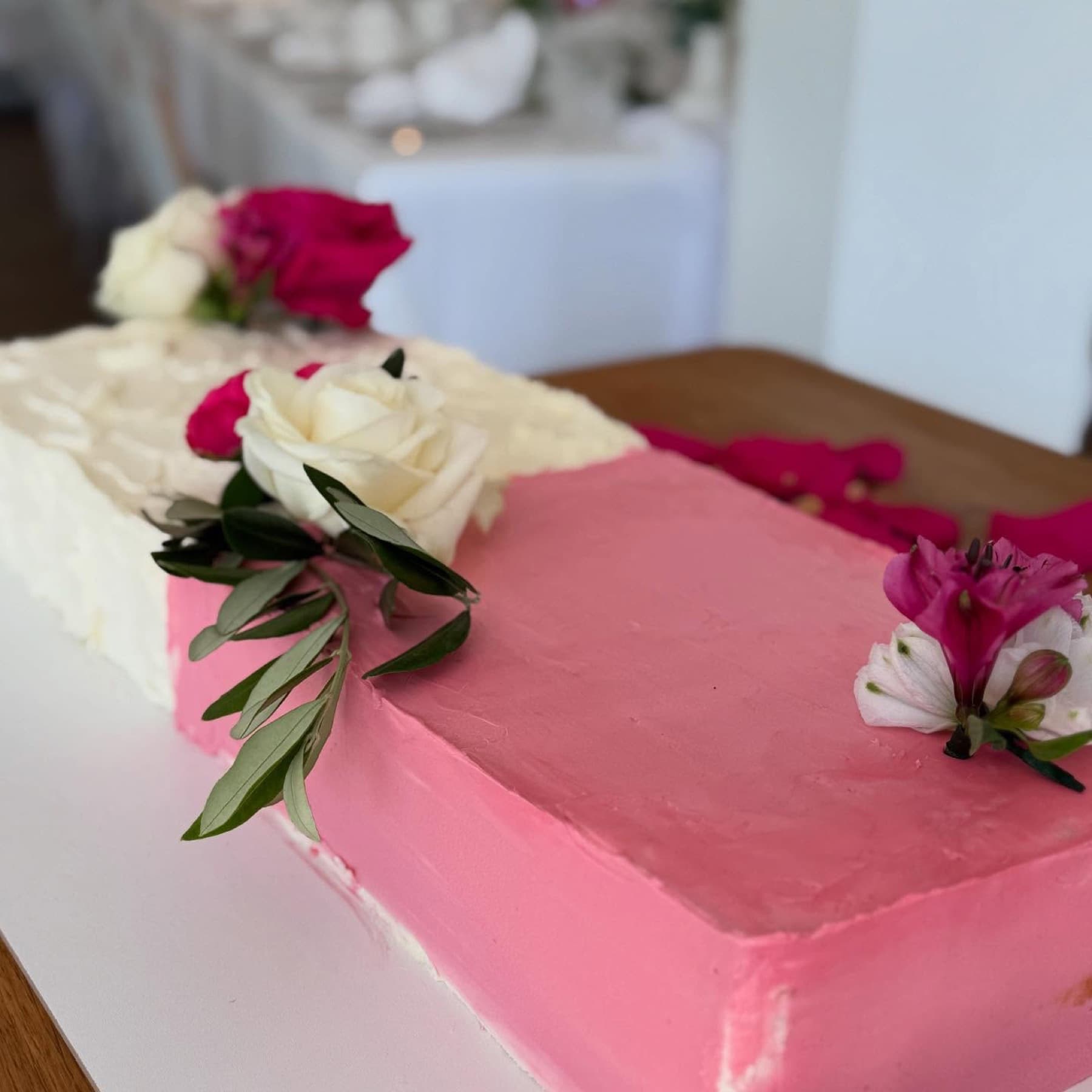 Rechteckige Torte in Pink und Weiß mit Blüten und Olivenzweigen